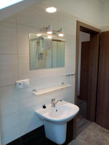 uma casa de banho com um lavatório branco e um espelho. em Ivachnová 84 em Ivachnová