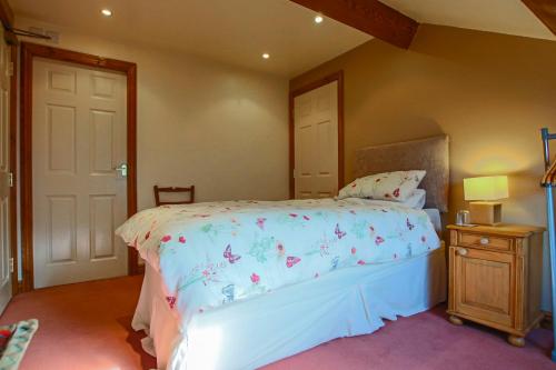 a bedroom with a bed with a bedspread with butterflies on it at Foxhill Fold in Gisburn