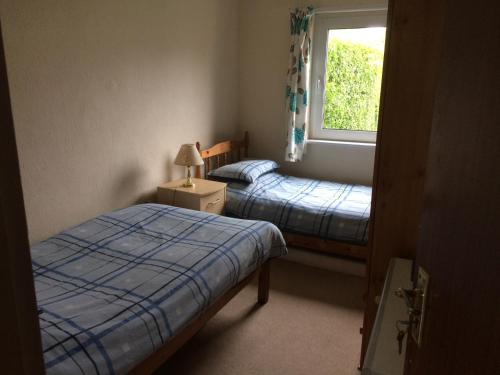 two beds in a small room with a window at Beech Road in Newport