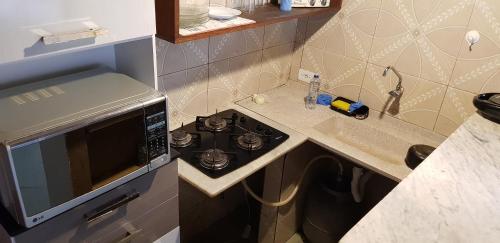 a small kitchen with a stove and a sink at Recanto dos Albatrozes in Boicucanga