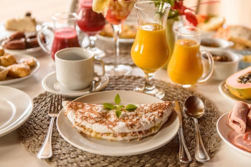 a table topped with a plate of food and drinks at Pousada Corveta in Fernando de Noronha