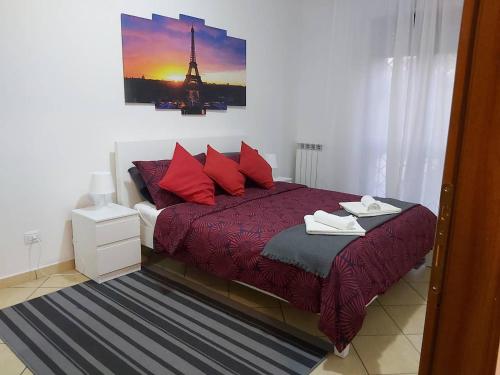 a bed with red pillows and a picture of the eiffel tower at Hillary E Vale Room in Rome