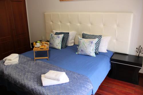 a bed with a blue comforter and pillows at Doca do Cavacas Apartment in Funchal