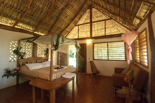 a bedroom with a bed and a table in a room at Totoco Eco-Project in Balgue