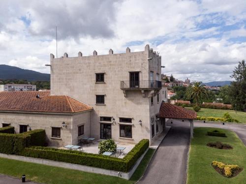 a large white building with a balcony and a yard at Parador de Tui in Tui