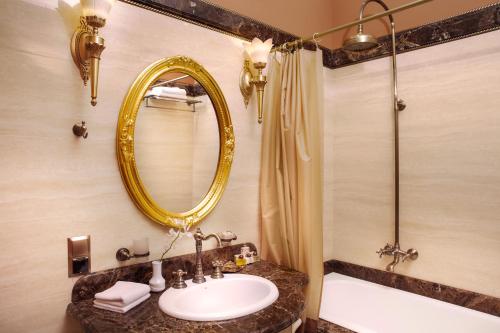 a bathroom with a sink and a mirror and a tub at Staro Hotel in Kyiv