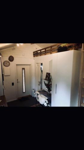 a room with a bed and a white refrigerator at Villa Lillgården with Sauna and Jacuzzi in Norrköping