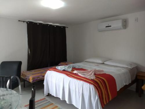 1 dormitorio con cama, mesa y ventana en Residencial Fran Chiattone, en Natal