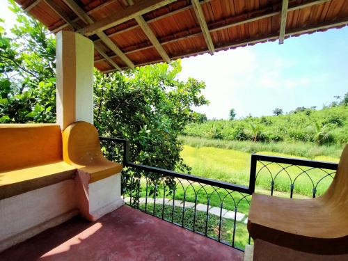 a balcony with a view of a field at Porsu in Canacona