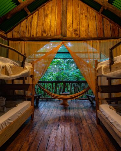 a room with a hammock in a tree house at La Tigra Rainforest Lodge in Fortuna