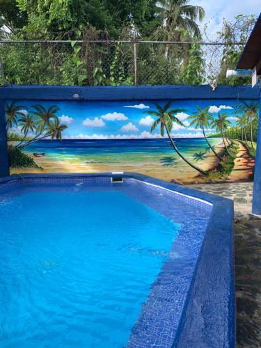 a swimming pool with a mural of the beach at Sana El Jardin Secreto in Santiago de los Caballeros