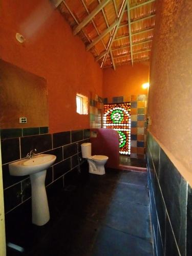 a bathroom with a sink and a toilet and a window at Porsu in Canacona