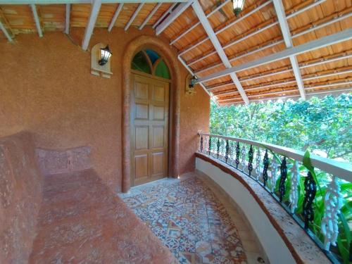 a porch with a wooden door and a balcony at Porsu in Canacona