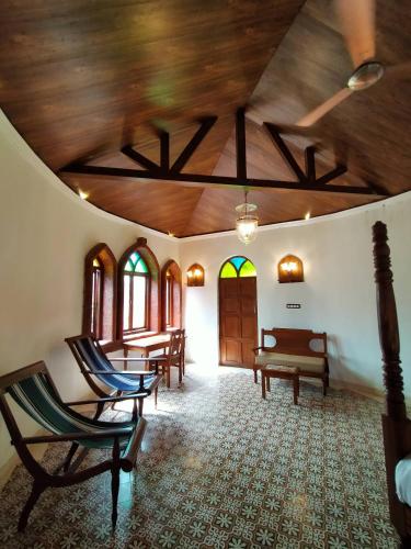 a room with chairs and a wooden ceiling at Porsu in Canacona