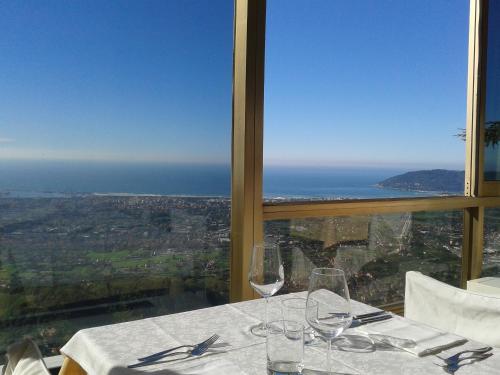 a table with wine glasses and a view of the ocean at Hotel Ristorante Radar in Carrara