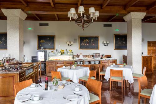 ein Restaurant mit Tischen und Stühlen und einer Küche in der Unterkunft Parador de Tui in Tui