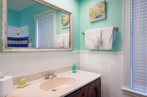 y baño con lavabo, espejo y toallas. en Coco Plum Inn, en Key West