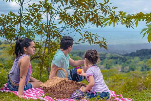 a group of people sitting on a picnic blanket at La Tigra Rainforest Lodge in Fortuna