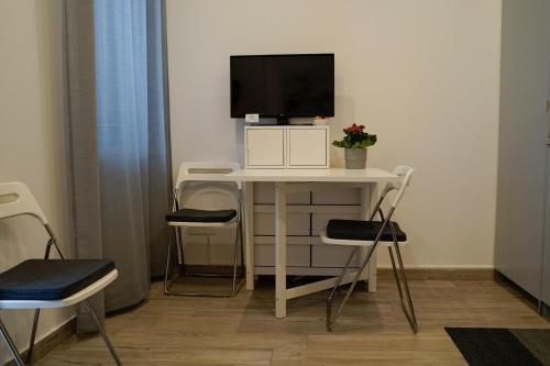 Pokój z biurkiem, telewizorem i krzesłami w obiekcie CATANIA CENTRAL DELUXE HOUSE w Katanii