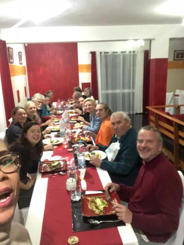 a group of people sitting at a long long table at Petite Flower Guest House in Talata-maty