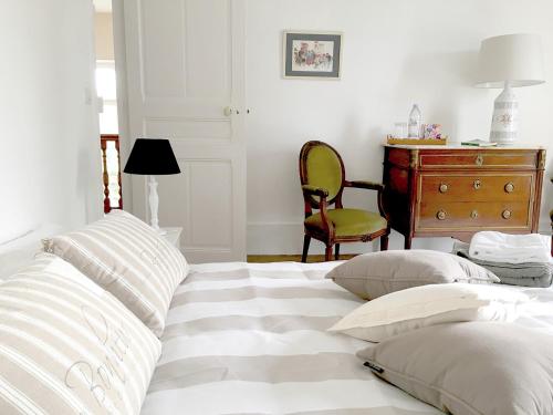 a bedroom with a bed with pillows and a desk at Les Chambres de LOUIS in Le Chesnay