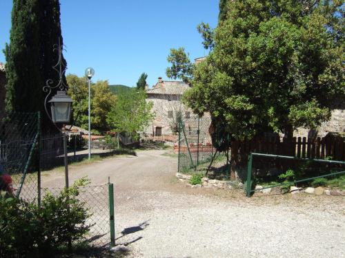 a fence in front of a house with a tree at Casa Crevole in Palazzina