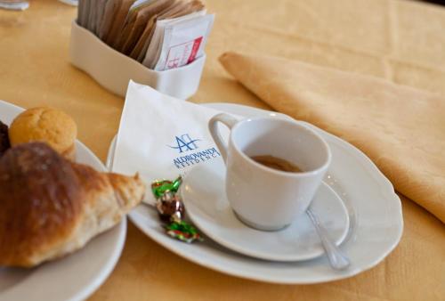 a cup of coffee and a pastry on a table at Aldrovandi Residence City Suites in Rome
