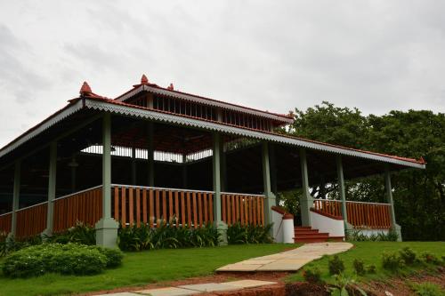 a large red building with a red roof at Porsu in Canacona