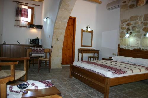 a bedroom with a bed and a table and a chair at Vafes Traditional Stone Houses in Vafés