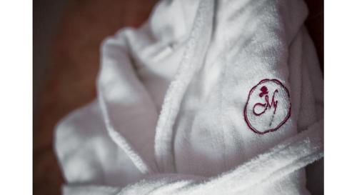a white robe with a red symbol on it at Garni Hotel Vila Milord Resort in Palić