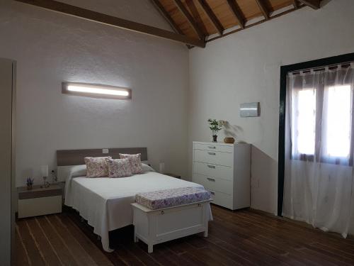 a bedroom with a bed and a dresser and a window at Siempreviva in Las Palmas de Gran Canaria