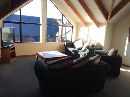 a living room with two couches and a tv at Snow Denn Lodge in Methven