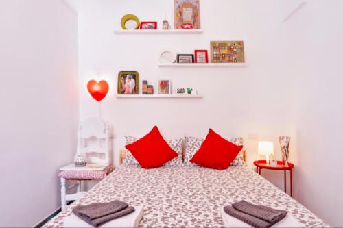 una camera da letto con un letto con cuscini rossi di Casa Coco a Lecce
