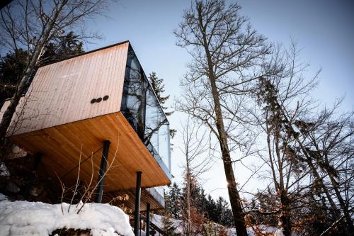 a building in the woods with snow on the ground at Miramonti Boutique Hotel in Avelengo