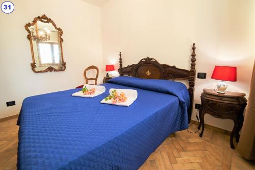 a bedroom with a blue bed with two towels on it at I Gigli del Belvedere in Montefiascone