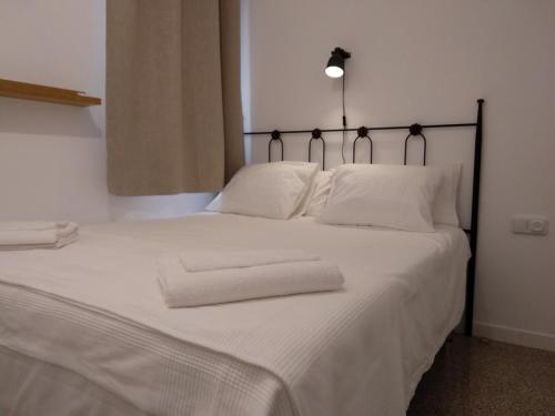 a large white bed with two towels on it at Cal Genís de Montmajor - WIFI in Montmajor