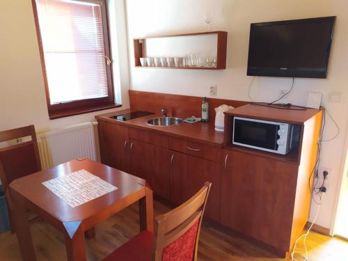 a kitchen with a microwave and a table with a sink at Chata Salma Jeseníky in Dolní Moravice