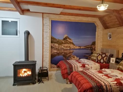 a room with two beds and a fireplace at Apartmani RUNOLIST in Žabljak