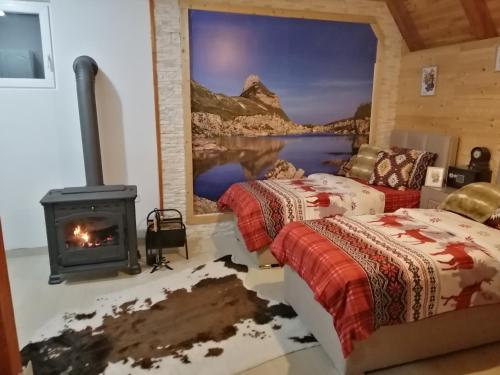 a room with two beds and a fireplace at Apartmani RUNOLIST in Žabljak
