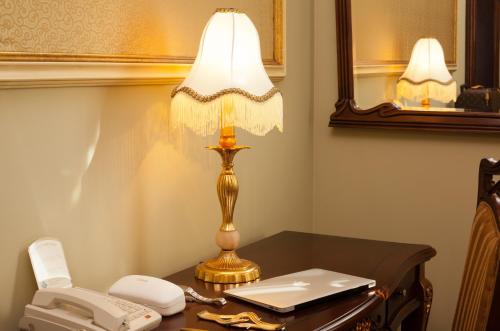 una lámpara sentada en un escritorio junto a un teléfono en Staro Hotel en Kiev