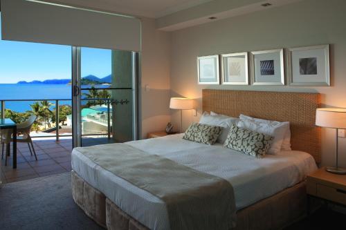 Vue Apartments Trinity Beach في شاطئ ترينيتي: غرفة نوم مع سرير وإطلالة على المحيط