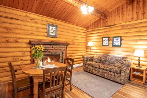 a living room with a table and a couch and a fireplace at Cusheon Lake Resort in Ganges