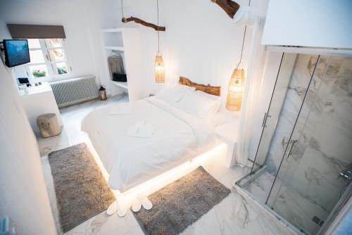 a bedroom with a white bed and a glass shower at Blue Mountain Guesthouse by Seablue in Arachova