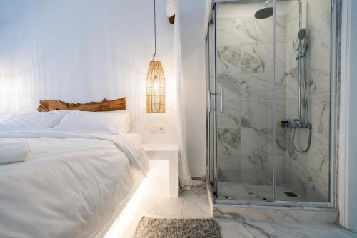a white bedroom with a shower and a bed at Blue Mountain Guesthouse by Seablue in Arachova