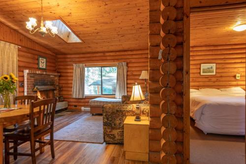 a bedroom in a log cabin with a bed and a table at Cusheon Lake Resort in Ganges