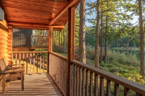a wooden porch of a cabin with a bench on it at Cusheon Lake Resort in Ganges