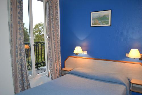 une chambre bleue avec un lit et une fenêtre dans l'établissement Hotel William's Opera, à Paris