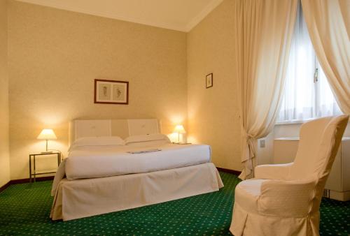 a hotel room with a bed and two chairs at Aldrovandi Residence City Suites in Rome