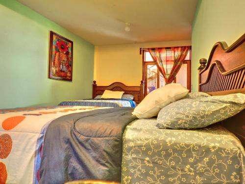 1 dormitorio con 2 camas y ventana en SHANTI SHANTI Hotel & Restaurante, en San Pedro La Laguna