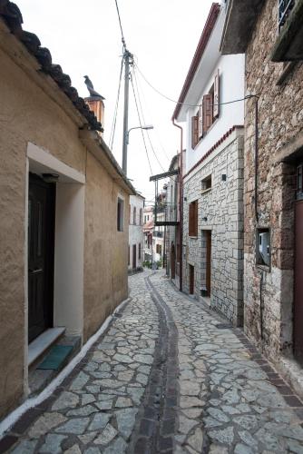 an alley in an old town with stone buildings at Blue Mountain Guesthouse by Seablue in Arachova